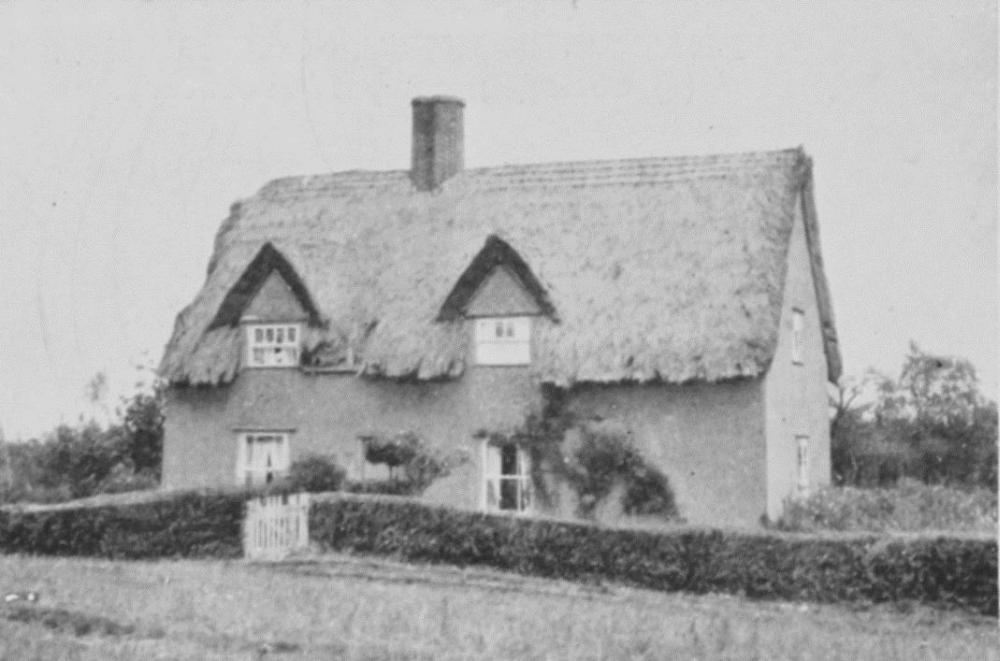 Black and white photograph of a farmhouse with a thatched roof